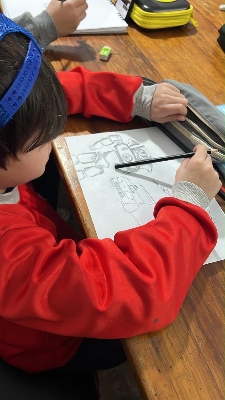 Manos trabajando en un dibujo sobre la mesa