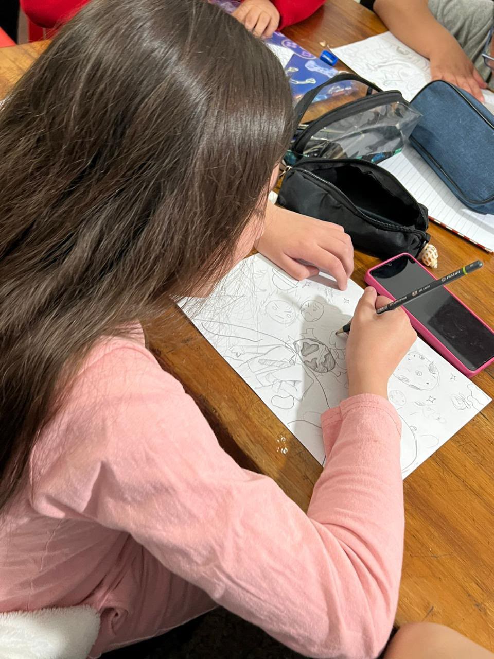 Dibujo y materiales durante una clase, vistos desde arriba